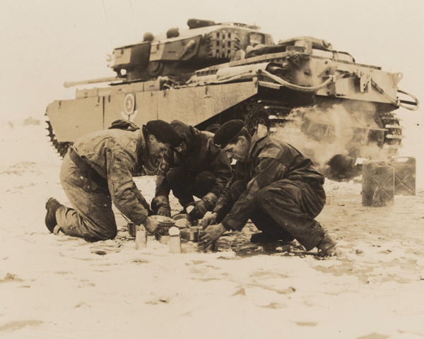 A tank crew from the 8th (King's Royal Irish) Hussars make a meal during their service on the Imjin front, 1951