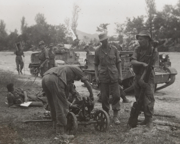 British troops examine a North Korean Maxim machine gun captured during their advance from the Pusan bridgehead in September 1950 