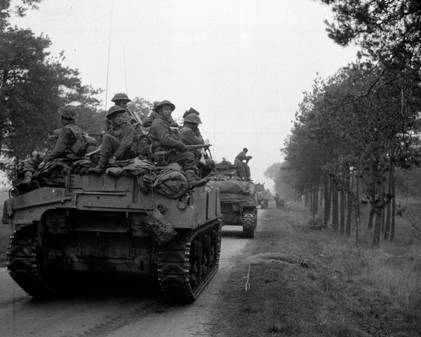Infantry hitch a ride on a tank of 4th Armoured Brigade, September 1944