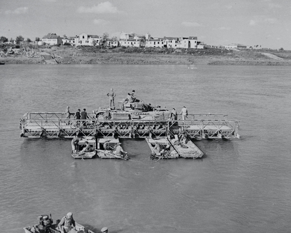 A Churchill tank crossing the River Po on a pontoon ferry, April 1945