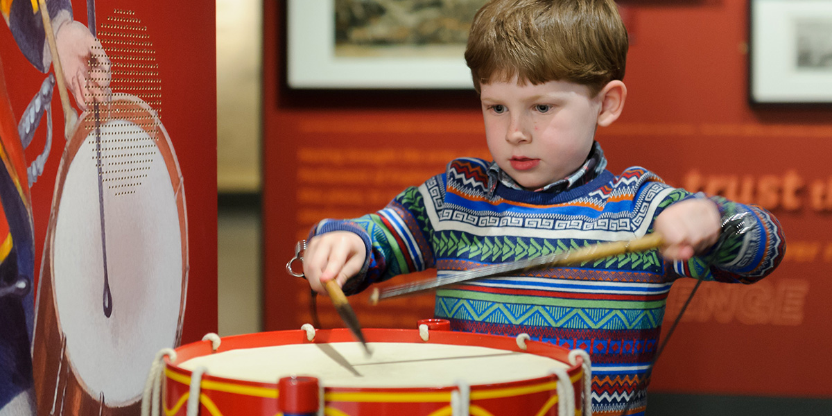 Child playing on a drumming interactive