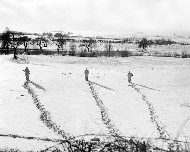 Soldiers of 6th Airborne Division advance through the snow in Belgium