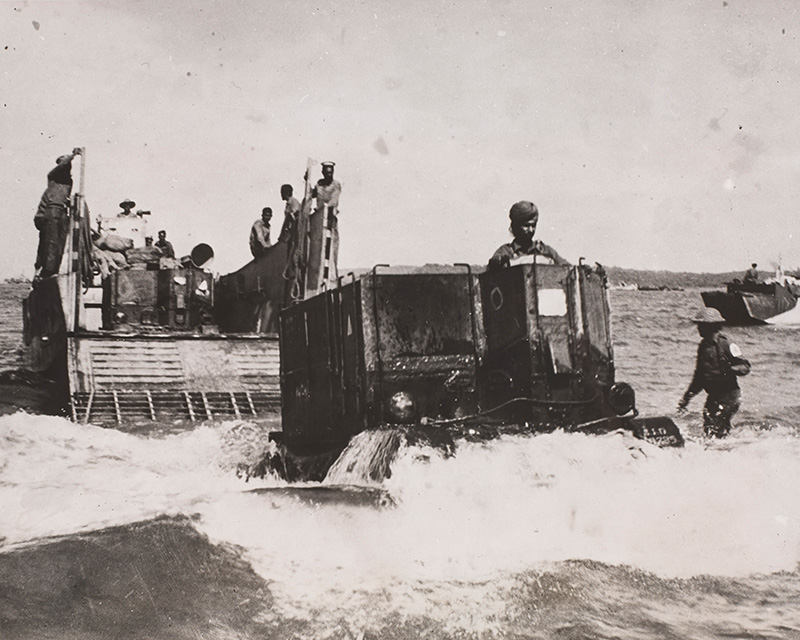 Soldiers disembarking from landing craft on the beach at Ramree Island, 15 February 1945