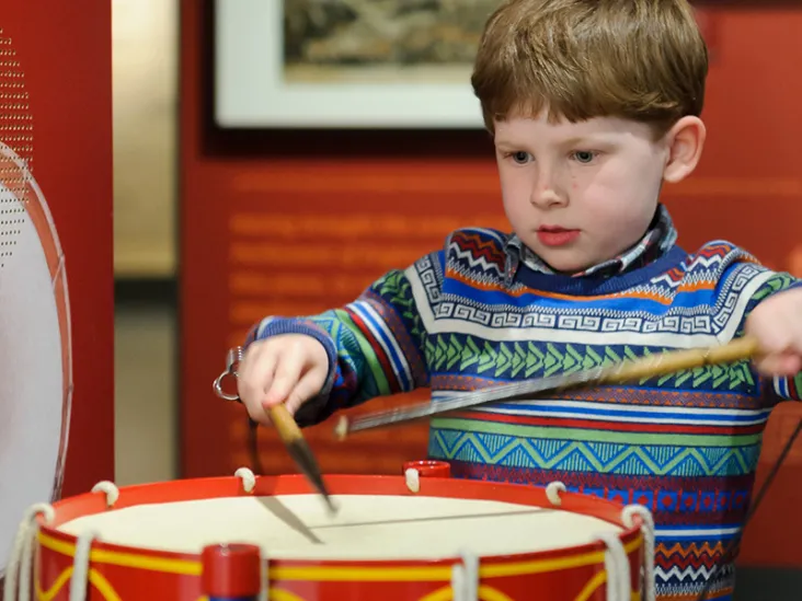 Child playing on a drumming interactive