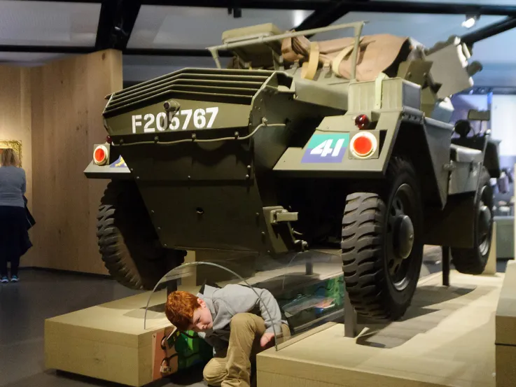 A child crawling under the Dingo scout car in Soldier gallery